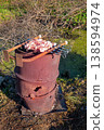 Barrel Used for Grilling Beef,. Lots of white smoke with a delicious aroma is coming out of the barrel hole. 138594974