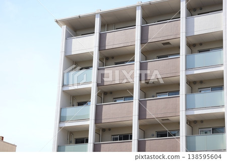 藍天白雲下，一棟新建的公寓大樓矗立在窗外。 138595604