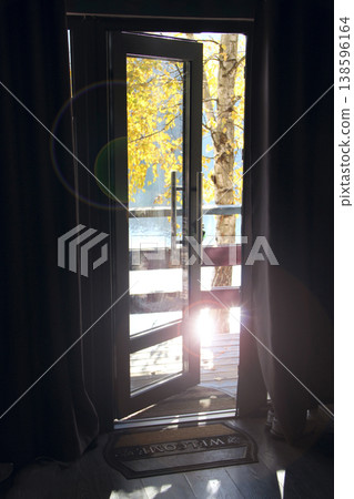 An open door leading to the lake in autumn. Room design. Room ventilation An open door leading to the lake in autumn. Room design. Room ventilation 138596164