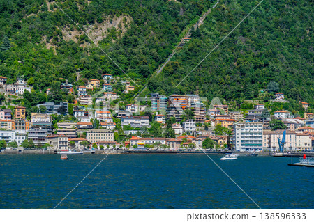 Como lake water resort. Multicolor houses Italian travel. Italy green mountain village with villa home outdoor Como lake water resort. Multicolor houses Italian travel. Italy green mountain village with villa home outdoor 138596333
