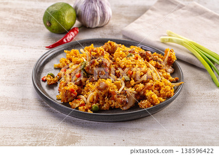 A delicious plate of Asian fried rice with meat and vegetables, surrounded by fresh ingredients. A delicious plate of Asian fried rice with meat and vegetables, surrounded by fresh ingredients. 138596422