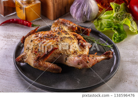 Whole roasted chicken seasoned with herbs and spices on a rustic plate Whole roasted chicken seasoned with herbs and spices on a rustic plate 138596476