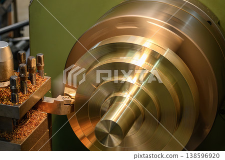 High-precision lathe machine performing a finish cut on brass material parts for a smooth and shiny surface. High-precision lathe machine performing a finish cut on brass material parts for a smooth and shiny surface. 138596920