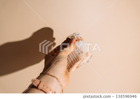 Hand holding rolled banknotes of Kazakhstani tenge on beige background, cash and savings concept Hand holding rolled banknotes of Kazakhstani tenge on beige background, cash and savings concept 138596946