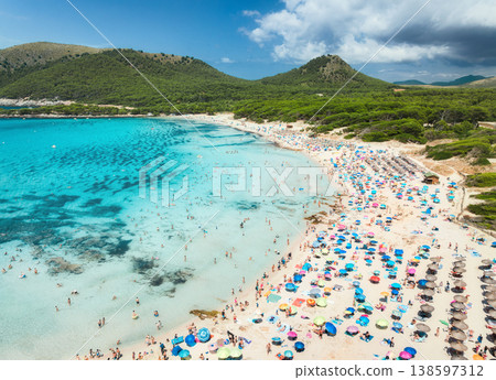 Aerial view of a crowded sandy beach with colorful umbrellas 138597312