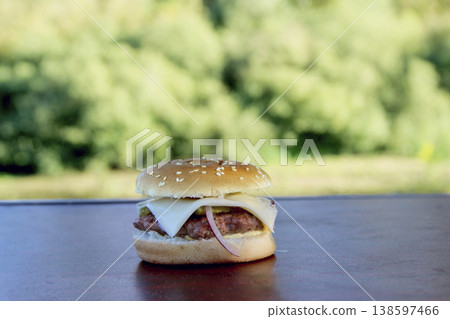 Cooking burger outdoors. Outdoor food. Fast food ready to eat. Tasty fast food Cooking burger outdoors. Outdoor food. Fast food ready to eat. Tasty fast food 138597466