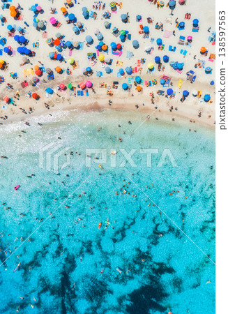 Aerial view of colorful umbrellas on sandy beach, swimming people Aerial view of colorful umbrellas on sandy beach, swimming people 138597563