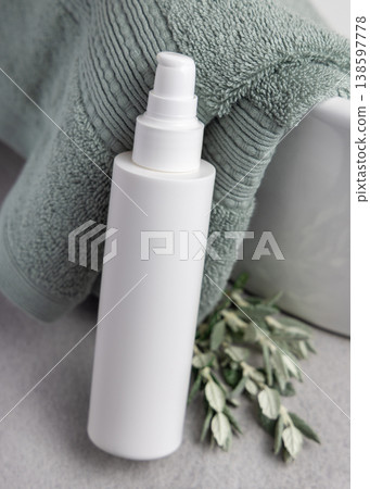 White pump cosmetic bottle mockup near leaves and sage green bath towel. Unbranded packaging 138597778