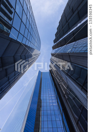 Low angle view of modern glass skyscrapers reaching into the sky Low angle view of modern glass skyscrapers reaching into the sky 138598345