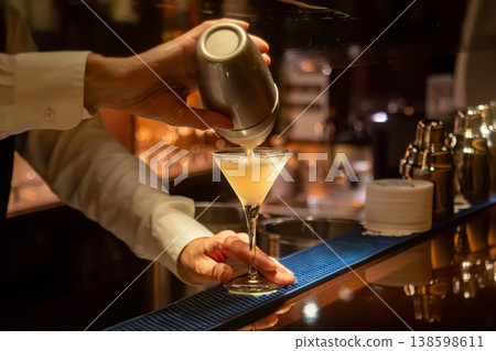 酒吧裡的夜景:調酒師正在調製雞尾酒。 酒吧裡的夜景:調酒師正在調製雞尾酒。 138598611