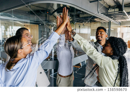 Energetic group of colleagues share high five after achievement 138598670
