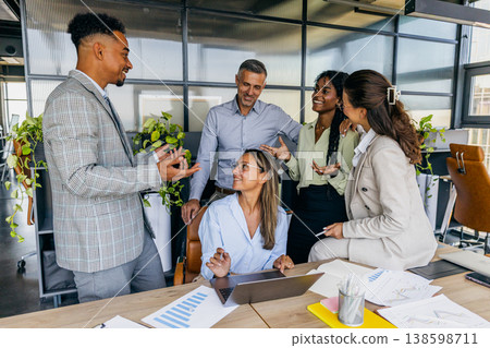 Team plans together. Group reviewing plans with charts and notes Team plans together. Group reviewing plans with charts and notes 138598711