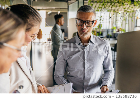 Consultant advising client on project plan in bright office 138598736