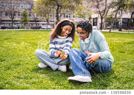 Teenagers sharing smartphone content with friends outdoors 138598830