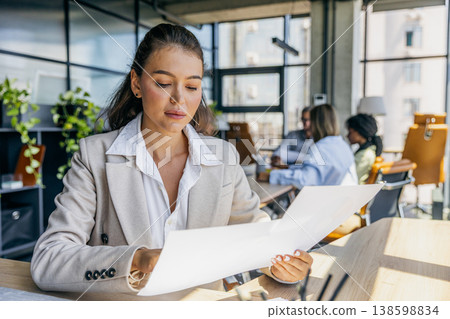Focused Female Analyzing Charts Meticulously. Woman Carefully Inspecting Printed Data And Diagrams Focused Female Analyzing Charts Meticulously. Woman Carefully Inspecting Printed Data And Diagrams 138598834