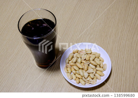 可樂和花生:一種簡單的零食和飲料。 可樂和花生:一種簡單的零食和飲料。 138599680