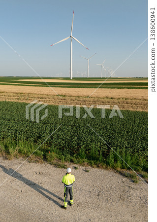 Engineer with digital tablet works on a field of wind turbines Engineer with digital tablet works on a field of wind turbines 138600941