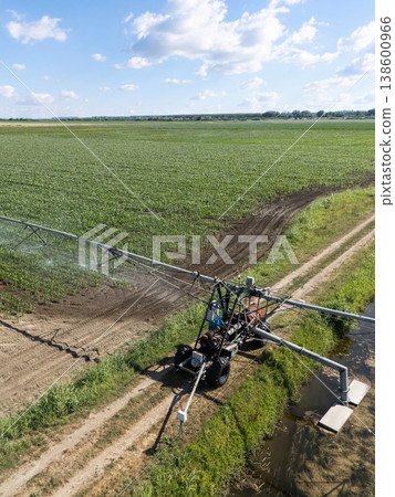 Autonomous machine is moving watering pivot along irrigation canal. 138600966