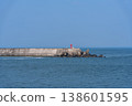 A harbor scene with seawalls and breakwaters lining the coast. 138601595