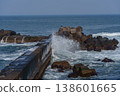 A breakwater with waves crashing against it and dilapidated wave-dissipating blocks: a scene of port infrastructure. 138601665