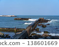 A breakwater with waves crashing against it and dilapidated wave-dissipating blocks: a scene of port infrastructure. 138601669