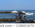 A breakwater with waves crashing against it and dilapidated wave-dissipating blocks: a scene of port infrastructure. 138601670