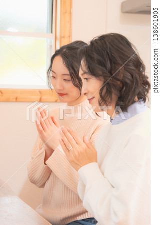 A mother and daughter praying for the deceased at home (retro style) A mother and daughter praying for the deceased at home (retro style) 138601905