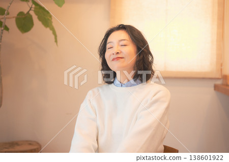 一位中年婦女(身著復古服飾)在家中為逝者祈禱後。 一位中年婦女(身著復古服飾)在家中為逝者祈禱後。 138601922