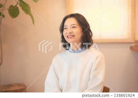 一位中年婦女(身著復古服飾)在家中為逝者祈禱後。 一位中年婦女(身著復古服飾)在家中為逝者祈禱後。 138601924