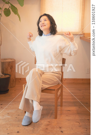 A middle-aged woman (in a retro style) after offering prayers for the deceased at home. 138601927