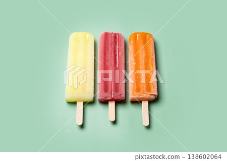 Colorful fruit popsicles on green background Colorful fruit popsicles on green background 138602064