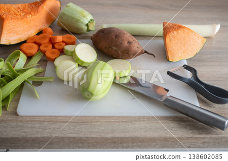 Top view of fresh vegetables being chopped on cutting board in home kitchen Top view of fresh vegetables being chopped on cutting board in home kitchen 138602085