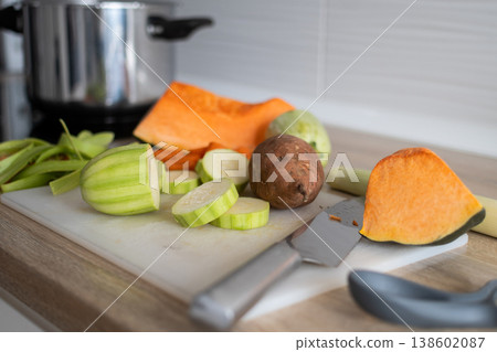 Top view of fresh vegetables being chopped on cutting board in home kitchen Top view of fresh vegetables being chopped on cutting board in home kitchen 138602087