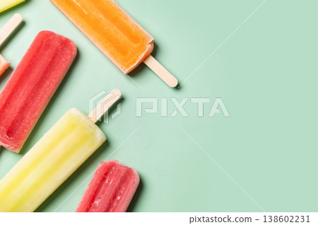 Colorful fruit popsicles on green background. Colorful fruit popsicles on green background. 138602231