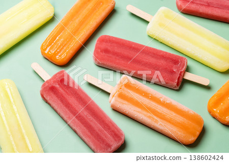 Colorful fruit popsicles on green background 138602424
