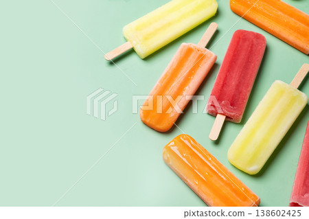 Colorful fruit popsicles on green background Colorful fruit popsicles on green background 138602425