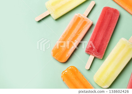 Colorful fruit popsicles on green background Colorful fruit popsicles on green background 138602426