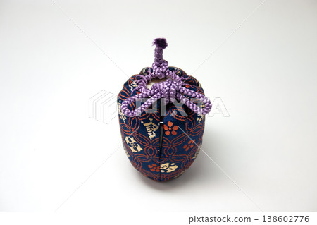 A tea caddy wrapped in a purple silk pouch. 138602776