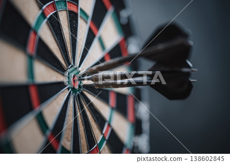 Darts grouped in bullseye on dartboard macro 138602845