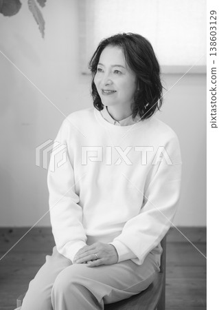 A middle-aged woman after offering prayers for the deceased at home (black and white) A middle-aged woman after offering prayers for the deceased at home (black and white) 138603129
