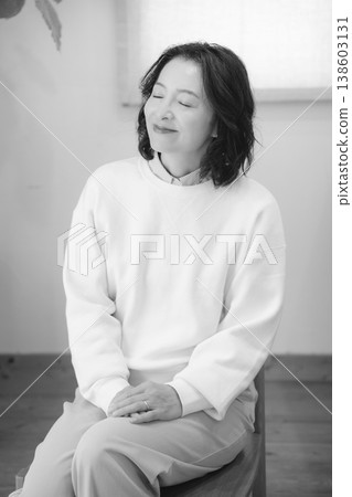 A middle-aged woman after offering prayers for the deceased at home (black and white) A middle-aged woman after offering prayers for the deceased at home (black and white) 138603131