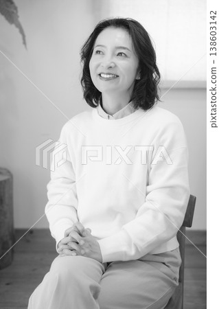 一位中年婦女在家中為逝者祈禱後（黑白照片） 138603142