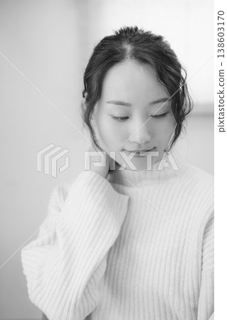 A daughter prays for her deceased loved one at home (black and white) 138603170