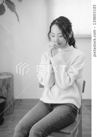 A daughter prays for her deceased loved one at home (black and white) A daughter prays for her deceased loved one at home (black and white) 138603185