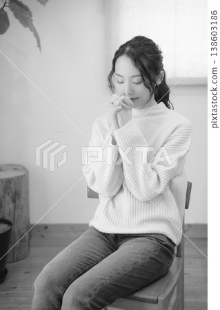 A daughter prays for her deceased loved one at home (black and white) A daughter prays for her deceased loved one at home (black and white) 138603186