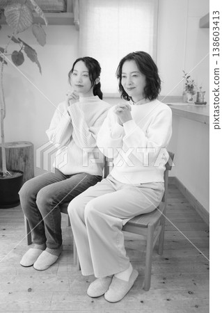 A mother and daughter pray for the deceased at home (black and white) A mother and daughter pray for the deceased at home (black and white) 138603413