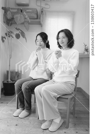 A mother and daughter pray for the deceased at home (black and white) A mother and daughter pray for the deceased at home (black and white) 138603417