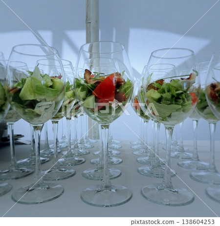 Fresh salad and bacon in verrine glass served on white tablecloth at food reception Fresh salad and bacon in verrine glass served on white tablecloth at food reception 138604253