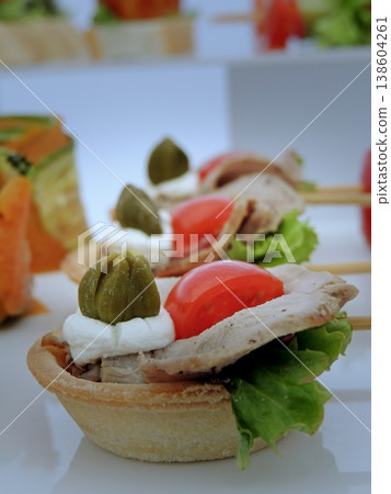 Elegant appetizer basket with ham and greens an white table cloth close up Elegant appetizer basket with ham and greens an white table cloth close up 138604261