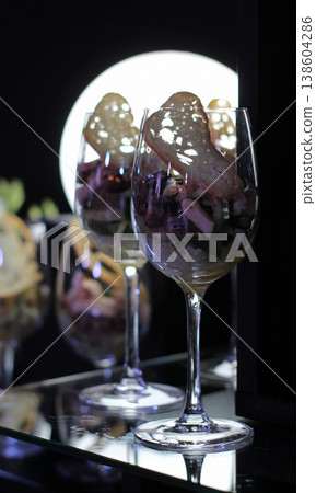 Fresh appetizer with crouton in elegant wine glasses illuminated on black background Fresh appetizer with crouton in elegant wine glasses illuminated on black background 138604286